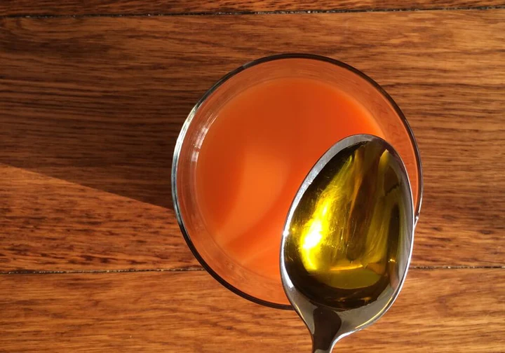 Löffel mit Hustensirup über einem Glas